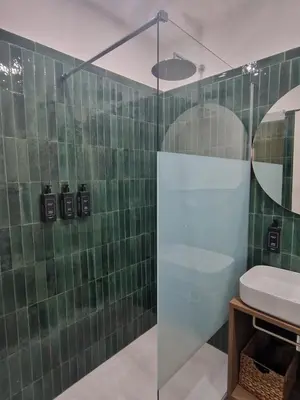 a green tiled bathroom with a sink and a shower at Casa Fortuna 278 in Rome