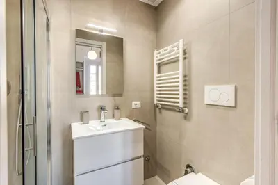 a bathroom with a sink and a shower and a mirror at St Peter Miracle Suite in Rome