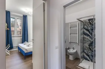 a bedroom with a bed and a bathroom with a mirror at Domus Alessandro City Apartment in Rome