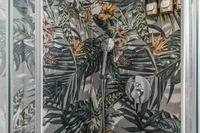 a shower in a bathroom with a tropical wallpaper at Domus Alessandro City Apartment in Rome
