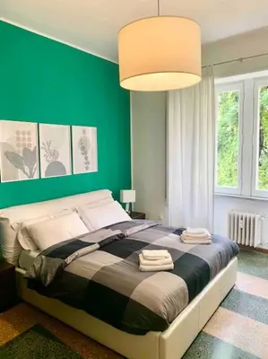 a bedroom with a large bed with a green wall at Lovely apartment near Rome Vatican in Rome