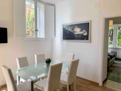 a dining room with a glass table and white chairs at Lovely apartment near Rome Vatican in Rome