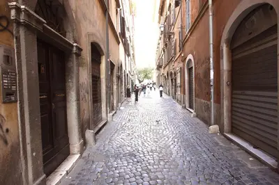 an alley with people walking down a cobblestone street at Top floor studio in Campo de Fiori in Rome