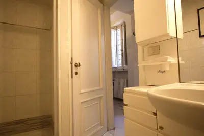 a white bathroom with a sink and a mirror at Top floor studio in Campo de Fiori in Rome