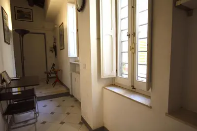 a hallway with a window and a table and chair at Top floor studio in Campo de Fiori in Rome