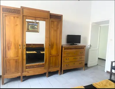 a bedroom with a large wooden cabinet and a television at Martino rooms Termini in Rome