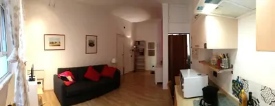 a living room with a black couch and red pillows at san giovanni - re di roma apartment in Rome
