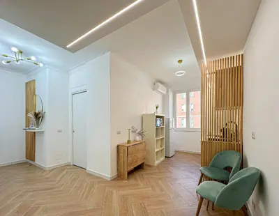 a living room with white walls and green chairs at Lilla Boutique Apartment in Rome