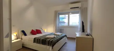 a white bedroom with a bed and a window at Casetta Cerquetti, a Monteverde in Rome