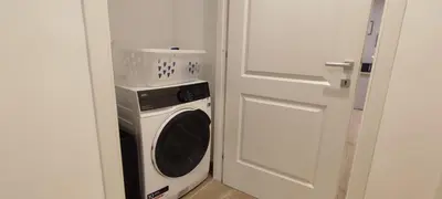 a washer and dryer in a room next to a door at Casetta Cerquetti, a Monteverde in Rome