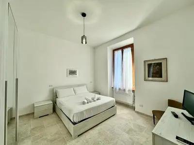 a white bedroom with a bed and a desk at Giuli-Etta a Testaccio in Rome