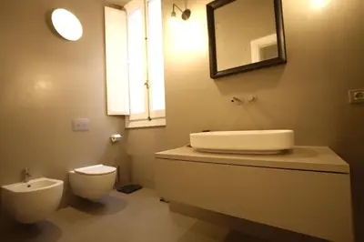 a bathroom with a sink and a toilet and a mirror at Cartari Holiday House in Campo de Fiori in Rome