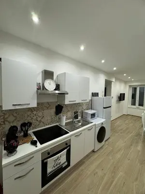 a kitchen with white cabinets and a counter top at Dimora Appia in Rome