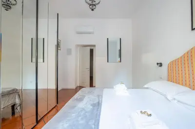a bedroom with a white bed and a glass wall at Colosseo 85 in Rome
