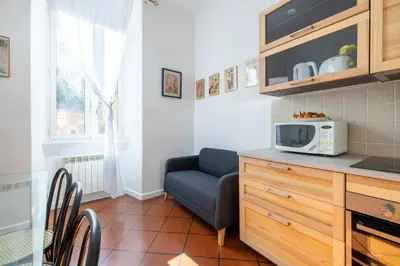 a kitchen with a blue couch and a microwave at Colosseo 85 in Rome