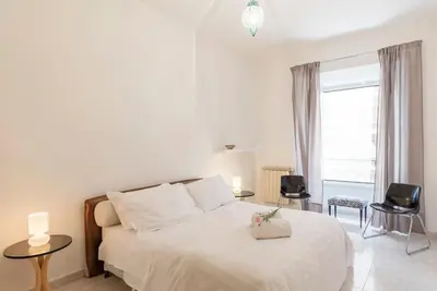 a bedroom with a white bed with two chairs and a window at La Bella Vita - Trastevere in Rome