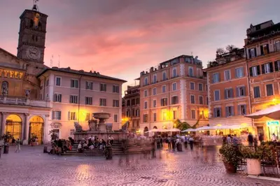 a city square at sunset with a clock tower at La Bella Vita - Trastevere in Rome