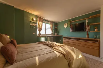 a bedroom with green walls and a large bed at Radice Home in Rome
