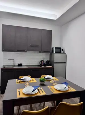 a kitchen with a table with plates and utensils at Eve&Gio Apartment Appio 2 room 2 bath in Rome