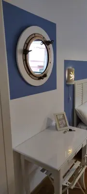 a white desk with a round mirror on a blue wall at FantAflat in Rome