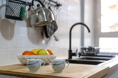 a kitchen counter with two cups and a bowl of fruit at Liu Home Tiburtina Stay in Rome in Rome