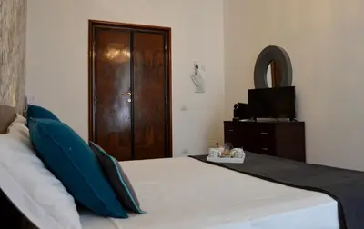 a bedroom with a bed with blue pillows and a television at Nobilcasa Suites in Rome