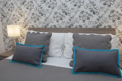 a bed with three pillows on top of it at Nobilcasa Suites in Rome