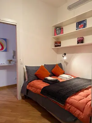 a bedroom with a bed with orange pillows on it at Exclusive Apartment in the Heart of Rome in Rome