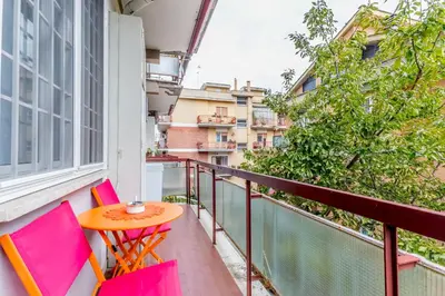 a small table and chairs on a balcony with pink chairs at White Living R-home in Rome