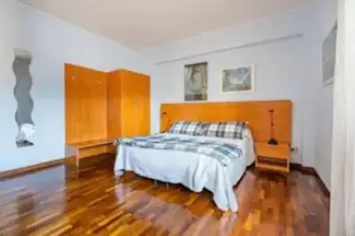 a bedroom with a bed and a wooden headboard at Notte al Vaticano in Rome