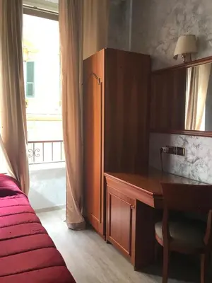 a bedroom with a desk and a bed and a window at Sandel Giubileo Hotel in Rome