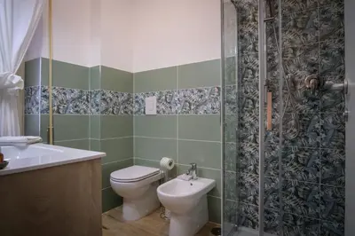 a bathroom with a toilet and a sink and a shower at Marconi Suites in Rome