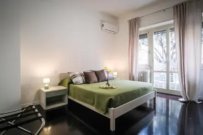 a bedroom with a green bed and a window at Marconi Suites in Rome