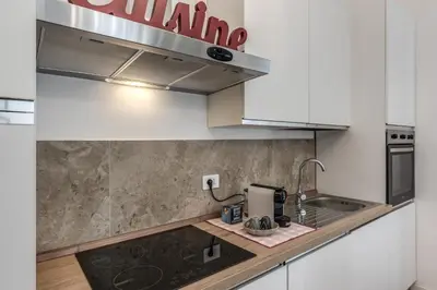 a kitchen with white cabinets and a sink at Fresh House Vaticano in Rome