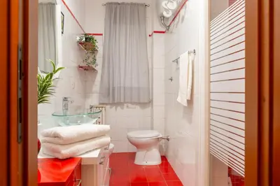 a bathroom with a toilet and a glass sink at Stanza Comoda e Silenziosa con Bagno Privato e Area Lavoro e Relax in Rome