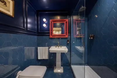 a blue tiled bathroom with a sink and a mirror at V Collection Condotti in Rome