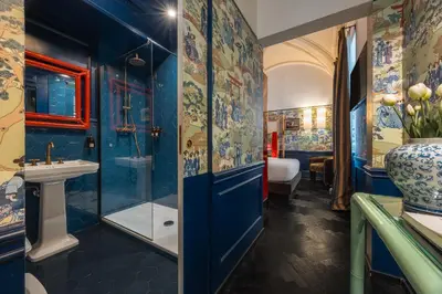 a blue bathroom with a shower and a sink at V Collection Condotti in Rome