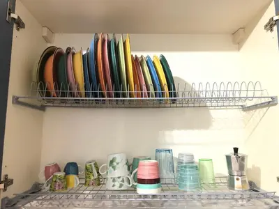 a shelf filled with different colored plates and bowls at LoL Apartment in Rome
