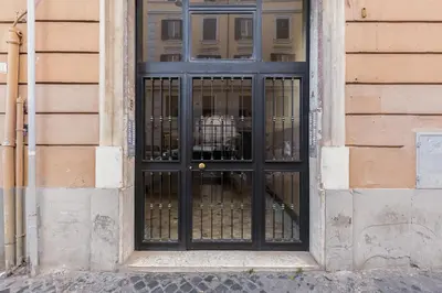 a black door with a dog behind a fence at InTheMoodForRome - Musei Vaticani in Rome