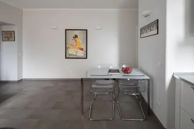 a white table and two stools in a room at Nice and spacious apartment near the Vatican and Starbucks in Rome