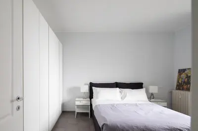 a bedroom with a bed and a white wall at Nice and spacious apartment near the Vatican and Starbucks in Rome