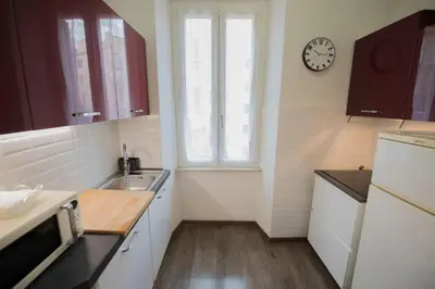 a kitchen with a sink and a clock on the wall at Domus Collazia - San Giovanni Apartment in Rome