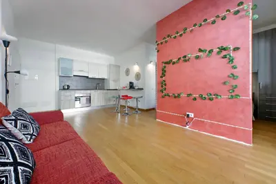 a living room with a red couch and a kitchen at Claudias flat by DomusDimore in Rome