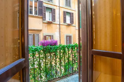 a window view of a balcony with purple flowers at Easybnb - Bear Home in Rome