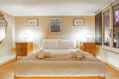 a large white bed in a room with two tables at Easybnb - Bear Home in Rome