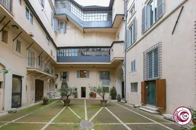 an empty courtyard in a building with potted plants at Palazzo Scapucci Apartment a Navona in Rome