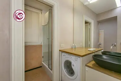 a bathroom with a sink and a washing machine at C M Piazza Cavour Elegant Flat in Rome