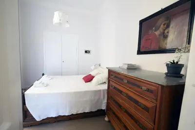 a bedroom with a bed and a dresser with a painting at Nido Degli Angeli in Rome