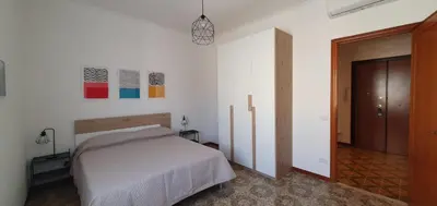 a bedroom with a bed and a door to a hallway at Attico a Gianicolense in Rome