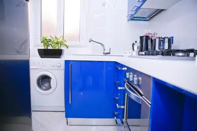 a blue kitchen with a sink and a washing machine at Mario Suite Spagna in Rome